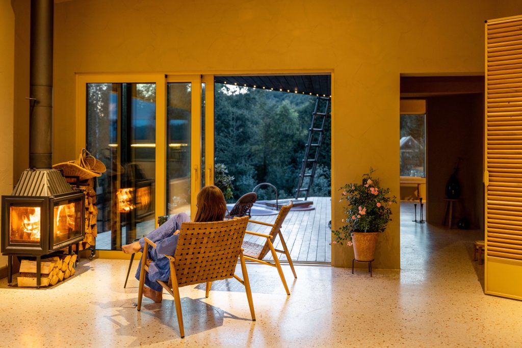 Woman in blue lounge set sitting by the fireplace