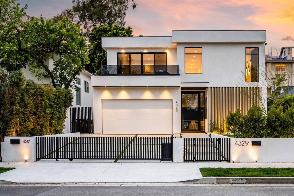 A modern home featuring a white fence and a garage, showcasing contemporary architecture and landscaping. | Featured Image for the Carport Builders & Garage Builders service landing page