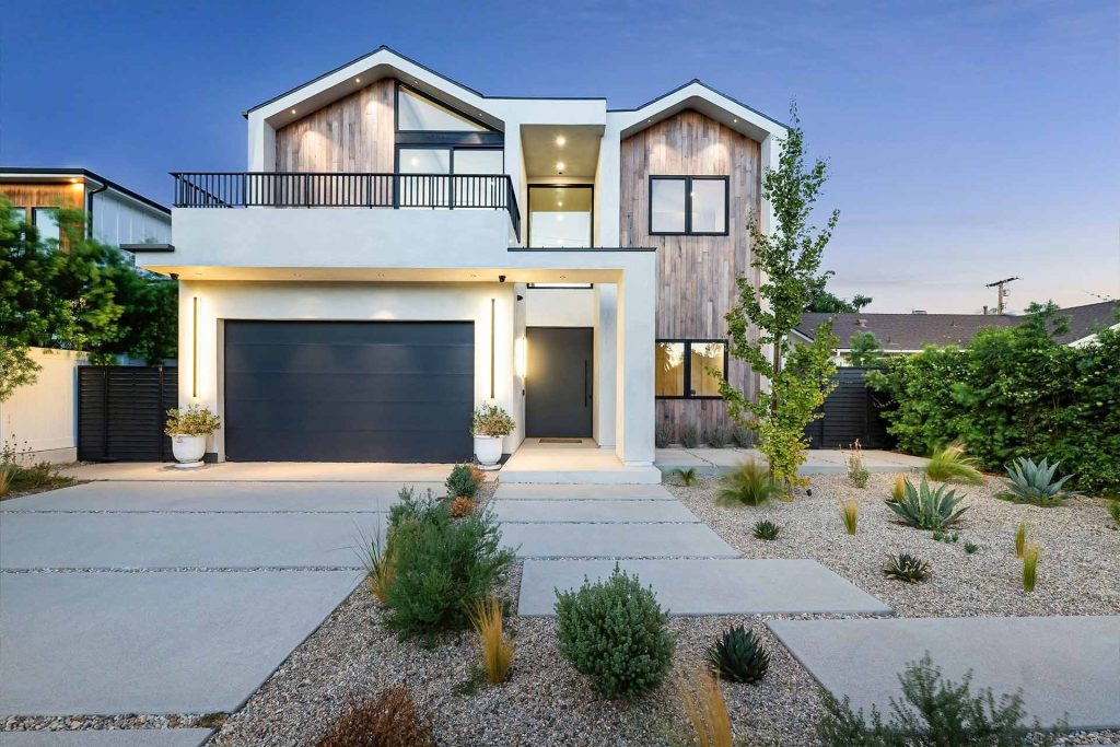 A modern home featuring a landscaped yard and a paved driveway, showcasing contemporary architectural design. | Featured Image for the Carport Builders & Garage Builders service landing page