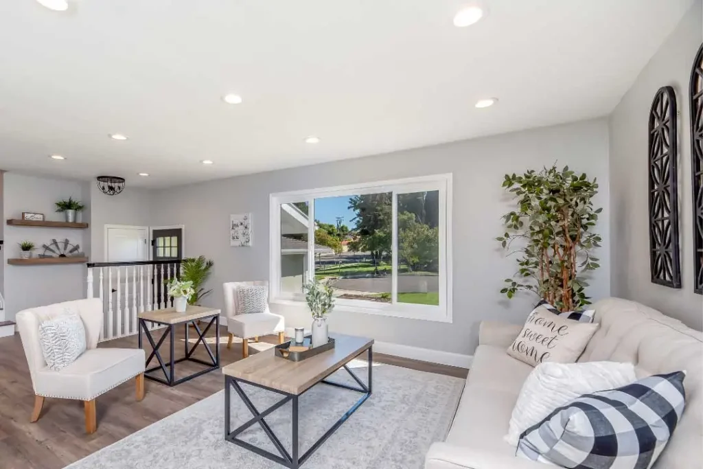 Modern living room with white walls, white couch and two comfy chairs | Image for the Rooming House Builders page.